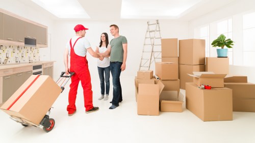 Packed moving boxes and furniture protection materials in a Kensington flat